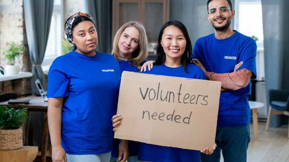 Four young multiracial volunteers in blue t-shirts