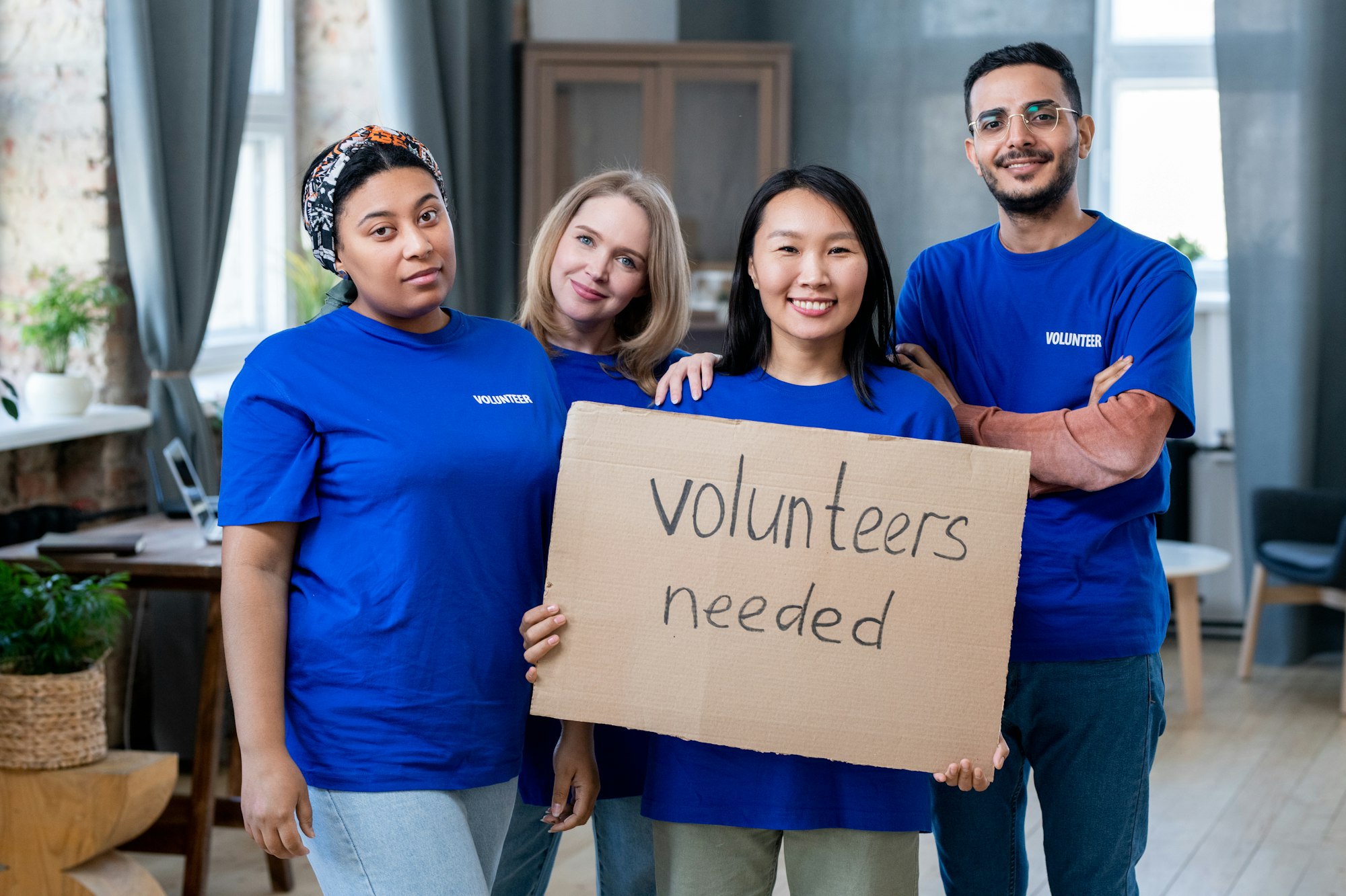 Four young multiracial volunteers in blue t-shirts