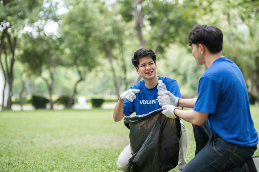 Volunteers Collecting Trash in a Park to Promote Environmental Awareness and Community Cleanliness